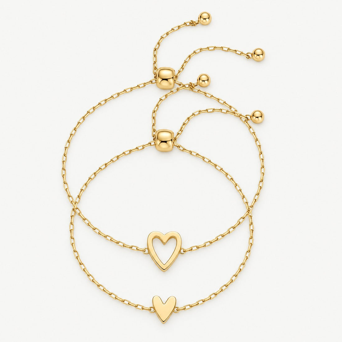Matching heart bracelets in gold — open heart and full heart, worn together