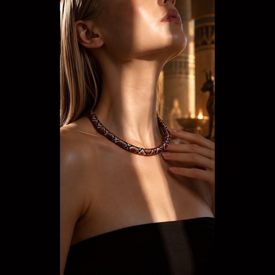 The braided snake necklace worn, caught in warm golden light