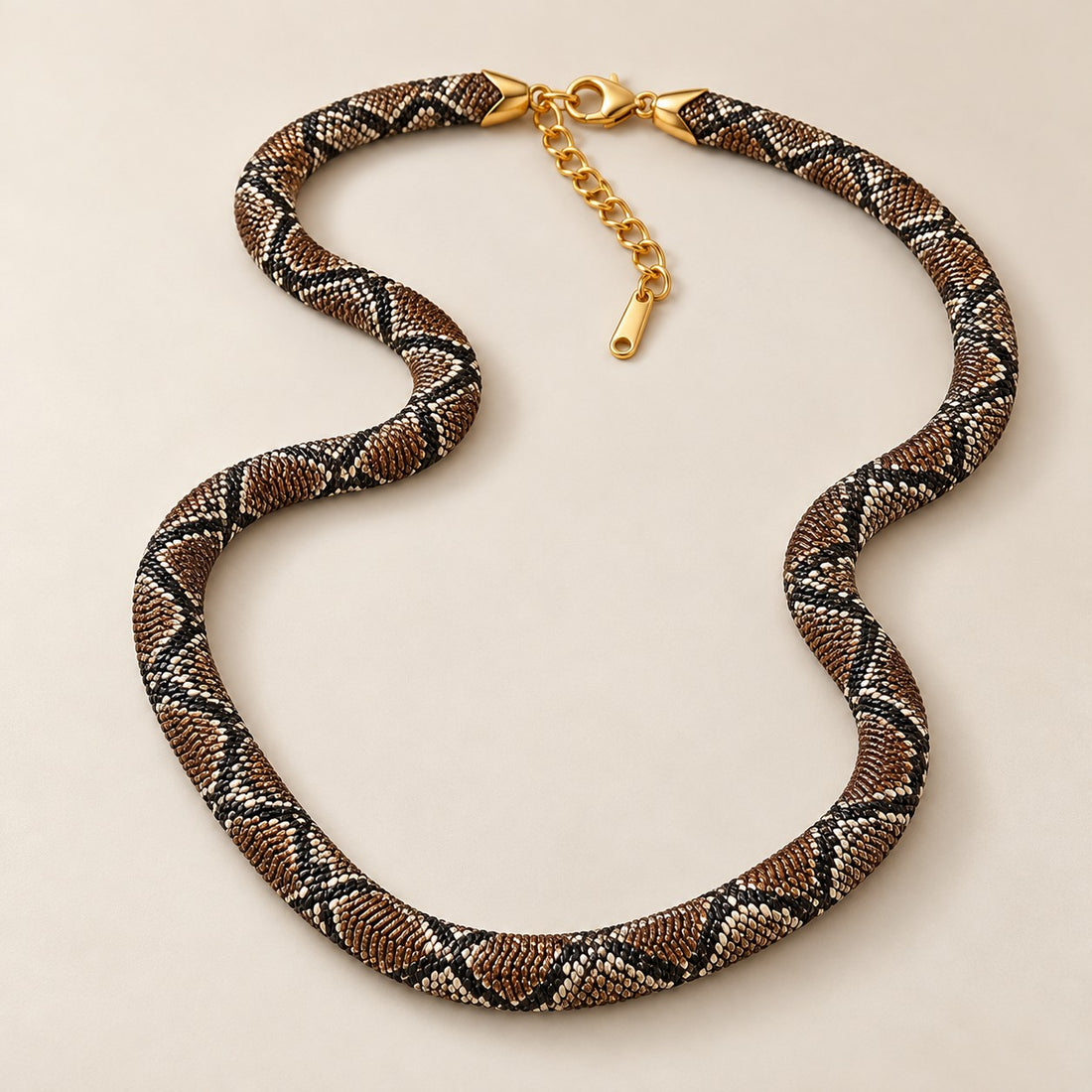 Braided snake necklace laid flat on cream